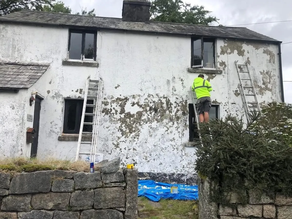 Cottage with blown, flaking render before repair in Newquay